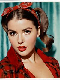 Sultry 27 year old in a red backless outfit pigtails and aviators on a dawn theater stage